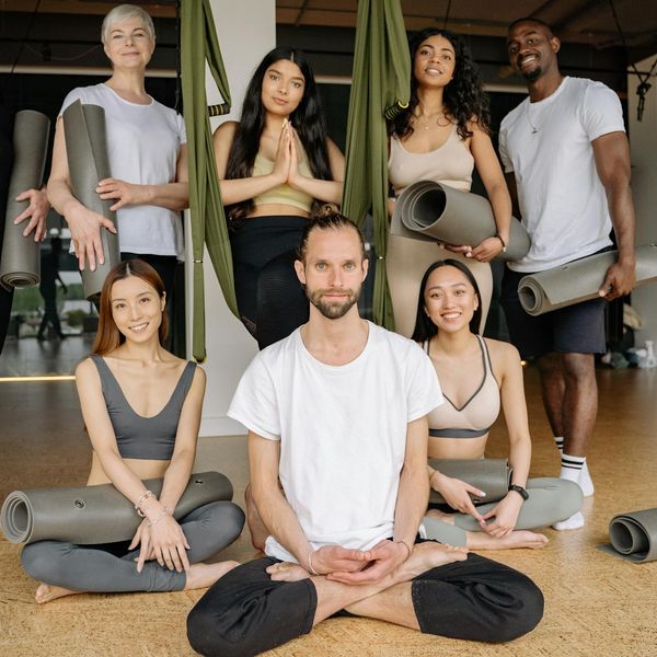 Diverse group of people smiling during a calm yoga class.